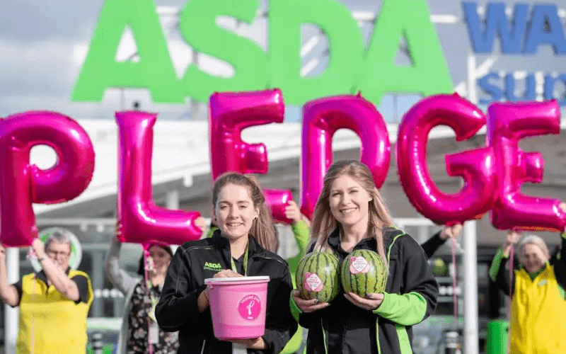 Asda employees holding a bucket of donations for their Tickled Pink campaign. 